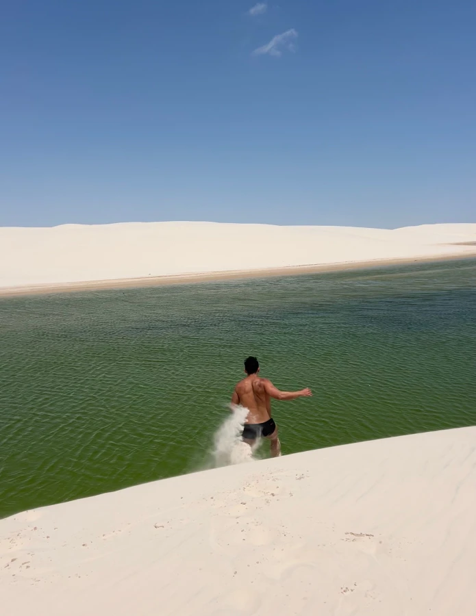 Homem correndo para dentro das lagoas dos lençóis Maranhenses um dos destinos mais visitados do Nordeste